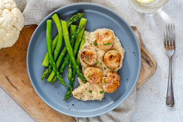 Pan-fried scallops with cauliflower and bean puree and asparagus