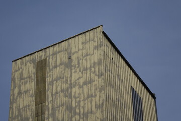 Cubic metal tower of factory building under blue spring sky, concept: industry, industrial...