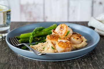 Pan-fried scallops with cauliflower and bean puree and asparagus