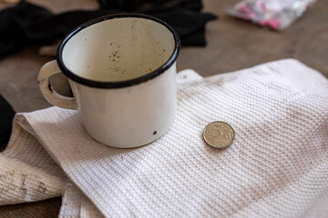  Russian soldier left his dirty cup and coin denomination 5 Rubles in occupied village school after battle. War of Russia against Ukraine. Concept of invasion and war price.  - obrazy, fototapety, plakaty