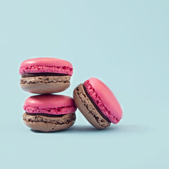 Cake macarons or macaroons, pink, on turquoise background from above, colorful almond cookies, pastel colors, vintage card