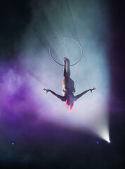 Aerial acrobat in the ring. A young girl performs the acrobatic elements in the air ring.