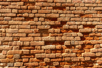 Wall texture with background with exposed red bricks. Ancient bricks corroded by weather and time. Ideal for background