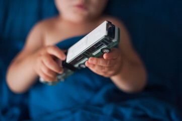 Toddler boy plays with car on bed close-up.