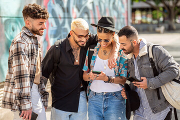 Group of multiracial young fashionable friends using cell phone, sharing content on social media....