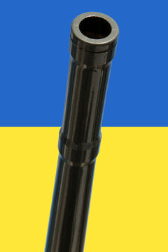 Kanonenrohr vor der Flagge der Ukraine