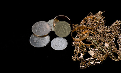 gold jewelry and Russian rubles coins on a black background