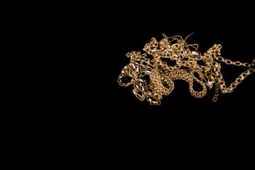 gold jewelry on a black background with space for text