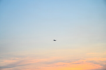 The plane flies. A passenger airplane on the sky. Jet flying at sunset.
