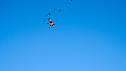 Bungee jumping. Young man is jumping from crane. Jump off a crane with a rope. Man having a good...