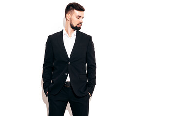 Portrait of handsome confident stylish hipster lambersexual model. Sexy modern man dressed in elegant black suit. Fashion male posing in studio near white wall. Isolated