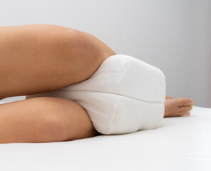 Orthopedic pillow for knees. Correct sleeping position legs for healthy spine