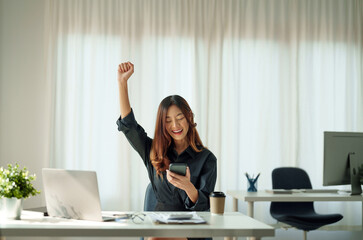 Portrait of happy young business asian woman celebrating success with arms up. positive expression,...
