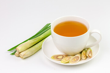 Cup of hot lemongrass tea with sliced and green leaf isolated on white background. Lemongrass for healthy herbal drink concept.