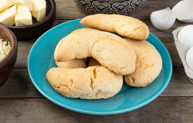 Chipas, typical south american cheese bun over wooden table with ingredients