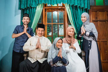 muslim family portrait looking at camera. wishing everyone happy eid mubarak and idul fitri
