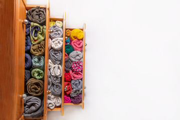 Open chest drawers with  vertical storaged twisting clothes. View from above. Storage of clothes in the wardrobe. Japanese method