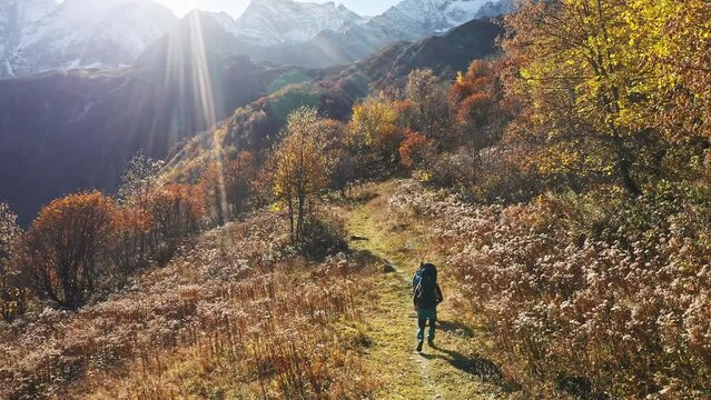 Young family hiking with a baby (in a carrier) in the mountains in autumn. Aerial drone shot. 