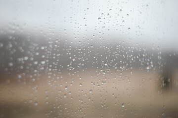 Natural pattern of rain drops on window glass surface.