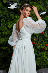 Fototapeta premium Beautiful tender young woman sexy brunette bride in a luxury white wedding dress lace chiffon Summer happiness awaits the groom before the wedding ceremony makeup accessory jewelry smile.