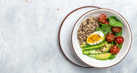Keto diet plate quinoa, avocado, egg, tomatoes, spinach and sunflower seeds on light background. Healthy food, ketogenic diet, diet lunch concept, place for text, top view