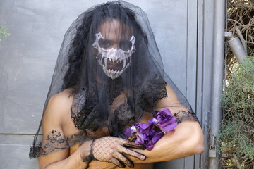 Spooky widow holding purple flowers