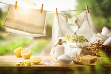 Ecological cleaning products on table and clothes hanging in nature