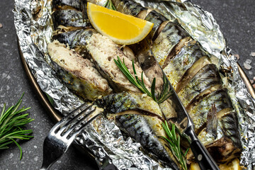 delicious roasted mackerel fish with lemon herbs and spices on a dark background, banner, Food...