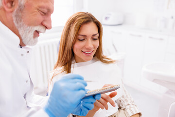 Dentist showing dentail veneers color palette to patient