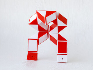 red and white bicolor magic snake Transformable twist puzzle in shape of robot transformer isolated...