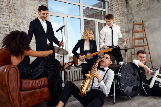 Repetition of multi ethnic jazz band in loft. Bass guitar player, electric guitar player, saxophonist and drummer at loft. Jazz music and jam session concept. passion for music and youth culture