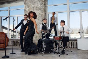 Young international musicians, a band performing on the loft stage. The concept of music, hobby, festival. Inspiration creativity.