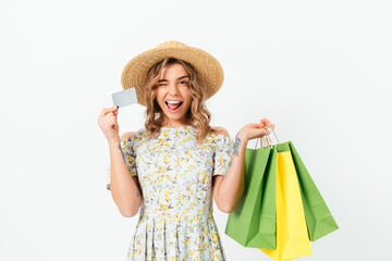 Happy young woman winking while holding shopping bags