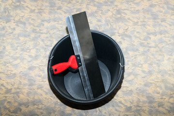 Clean spatula (trowel ) in an empty bucket close-up. Construction finishing works