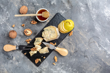 Blue cheese with pears, walnuts, nuts and honey. French cuisine. Vegetarian lunch. banner, menu, recipe place for text, top view