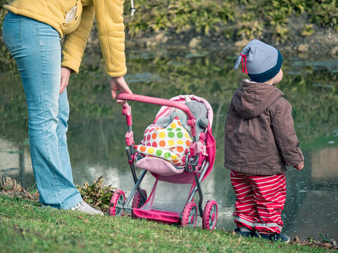 Mutter und Kind betrachten das Geschehen auf einem Teich