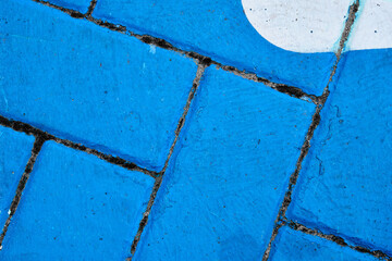 Abstract:  Blue bricks with white oval in top right.