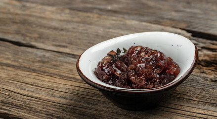 Red onion marmalade jam, confiture, chutney with wine and thyme on a wooden background, Delicious sauce. Gourmet. banner, menu, recipe place for text, top view