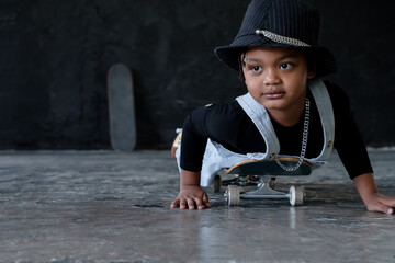 Close up little African kid boy wear hat, necklace chain and jeans bib practice playing and lying...
