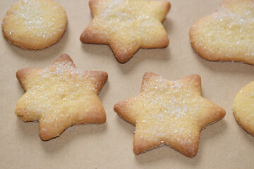 Baked cookies of various shapes and sizes sprinkled with sugar.