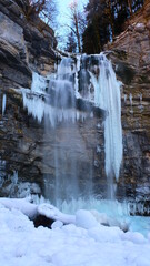Fototapeta na wymiar Waterfall in winter with ice stalactite