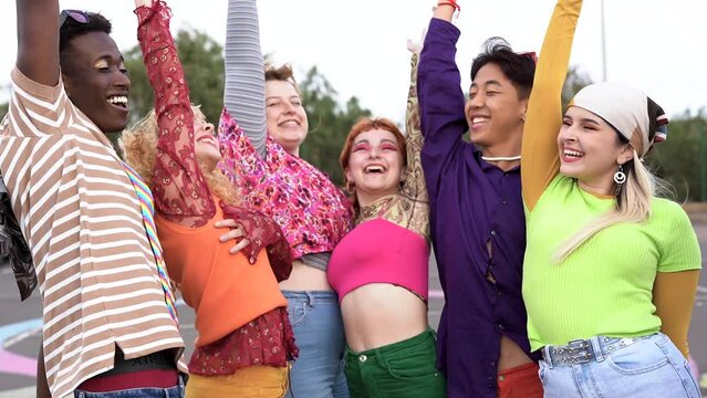 Happy young diverse people celebrating and stacking hands outdoor	
