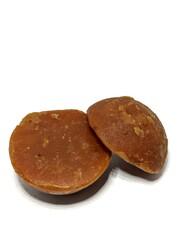 Organic palm sugar or Jaggery from India. Brown sugar isolated on white background
