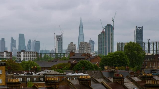 London, UK. Aerial view of a residential district with modern skyscrapers in the background in London, UK. Heavy clouds over the city. Time-lapse at day, panning video
