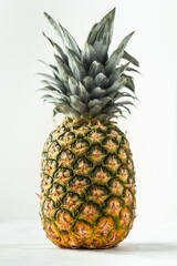 Fototapeta premium Whole pineapple isolated on the white background. Summertime background with tropic feel