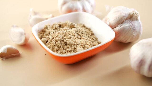 close up pf garlic and powder on wooden background,