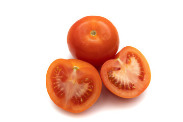 One whole tomato and one cut in half. Isolated on white background. The tomato is the fruit of the Solanum lycopersicum plant, which has culinary importance and is used as a vegetable.