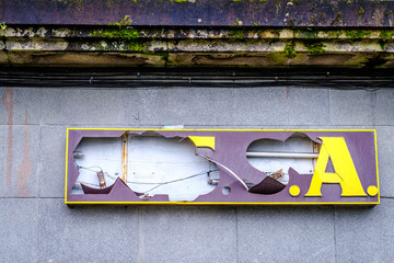 PONTEVEDRA, SPAIN - FEBRUARY 21, 2021: Backlit glass sign of an old company, destroyed by some act...