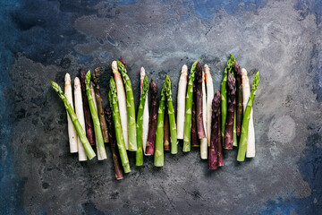Green, white and purple asparagus on a kitchen background - 500455516