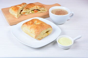 Puff pastry cake with vegetables and cheese, on wooden background